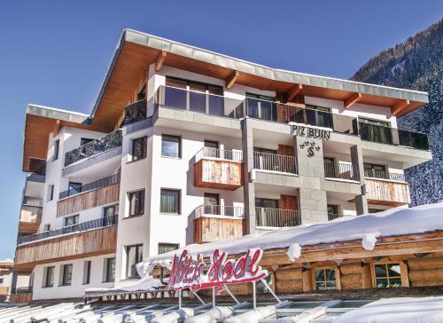 a hotel in the mountains with a sign in front of it at Hotel Piz Buin in Ischgl