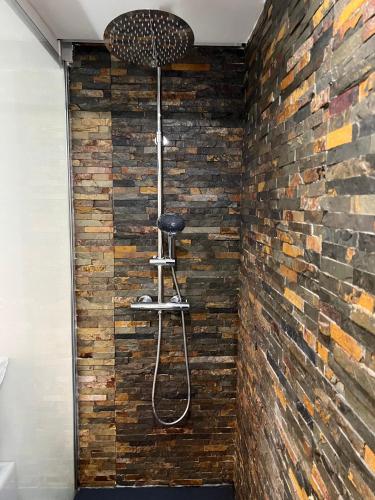 a shower in a room with a brick wall at Modern Room with Indoor Shower Near the River - Quarto Moderno com Duche interior Próximo da Ribeira in Vila Nova de Gaia
