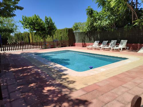 una piscina con tumbonas junto a una valla en Casa Rural Cortijo la Jimena, en Caravaca de la Cruz