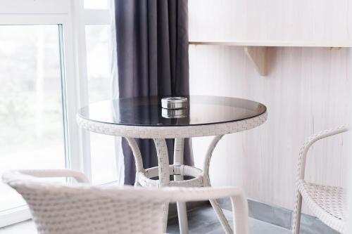 a round table in a room with two chairs at Silveroks Apartment in Prilimanskoye