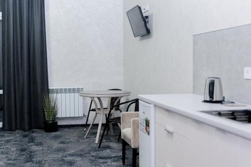 a kitchen with a counter and a table and chairs at Silveroks Apartment in Prilimanskoye