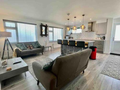 a living room with a couch and a kitchen at The Emslie Road Beach Flat in Falmouth