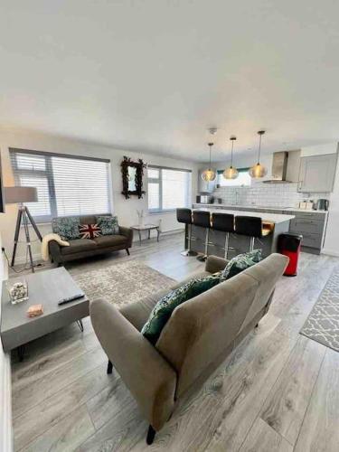 a living room with a couch and a piano at The Emslie Road Beach Flat in Falmouth