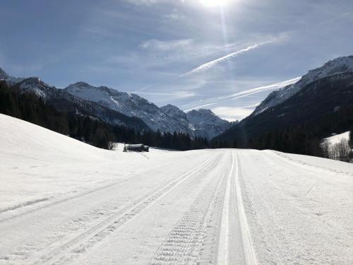a road covered in snow with mountains in the background at Hotel LÄRCHENHOF in Kleinarl