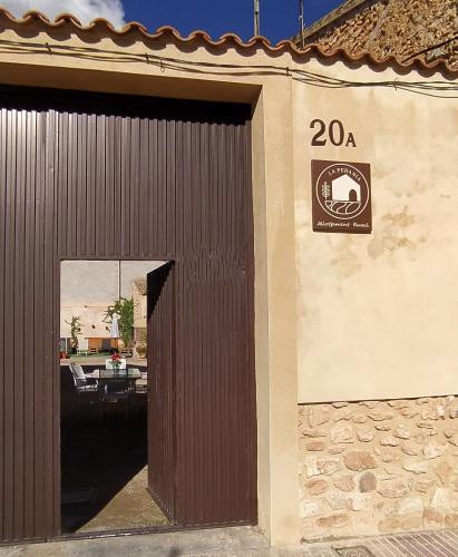 a building with a door with a sign on it at Casa rural LA PEDANIA in El Salse