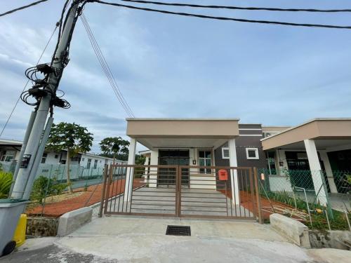 a house with a gate and stairs in front of it at RB HOMESTAY in Merlimau