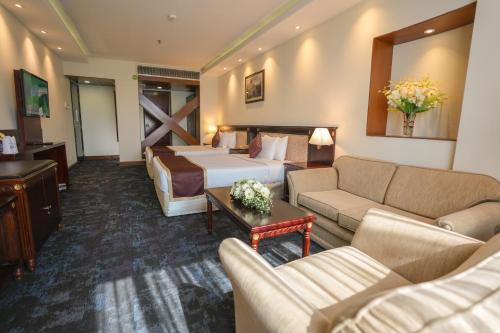 a hotel room with a bed and a couch at Hotel Sarina in Dhaka