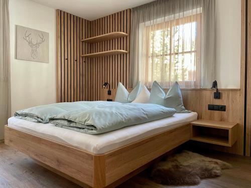 een slaapkamer met een groot bed en een raam bij Apartments Vaiolet in Santa Cristina in Val Gardena