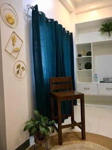 a wooden chair in front of a blue shower curtain at FN Lodge - town proper in Palompon