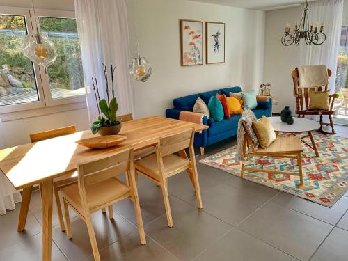 - un salon avec un canapé bleu et une table dans l'établissement Büelbad - Relax Holiday Apartment, à Kandersteg