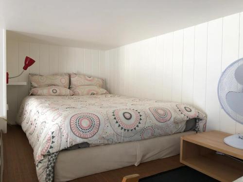 ein Schlafzimmer mit einem Bett und einem Tisch mit einer Lampe in der Unterkunft LE NOIR BOIS ET BLANC - Studio - Wifi - Centre Ville - Entrée Autonome in Quimper