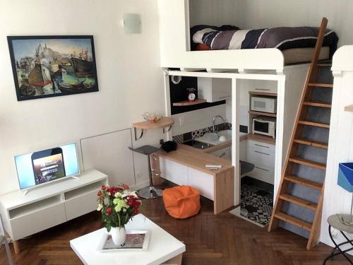 Kleines Zimmer mit einem Etagenbett und einem Schreibtisch. in der Unterkunft LE NOIR BOIS ET BLANC - Studio - Wifi - Centre Ville - Entrée Autonome in Quimper