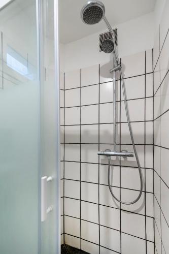 une douche avec pommeau de douche dans une salle de bain dans l'établissement Paris entre Opéra et Montmartre, à Paris