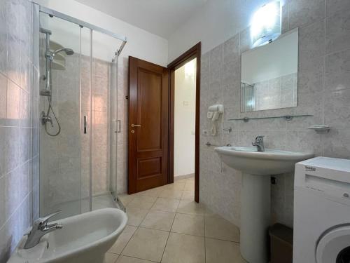 聖特奧多羅的住宿－Casa Vacanza la Suaredda，一间带水槽、淋浴和卫生间的浴室
