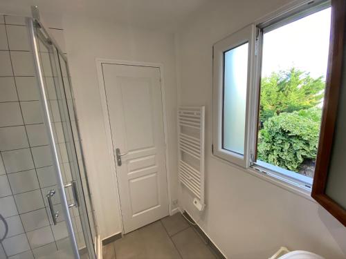 a bathroom with a shower and a window at Studio Chez Bob in Montreuil