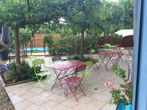 a group of tables and chairs in a garden at Chambres d'Hôtes du Clos Semper Felix in Sainte-Bazeille