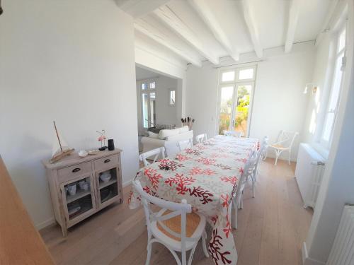une salle à manger blanche avec une table et des chaises dans l'établissement Arcachon-centre belle maison 5 chambres proche des plages à pieds, à Arcachon