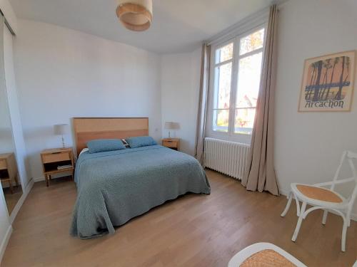 une chambre blanche avec un lit et une fenêtre dans l'établissement Arcachon-centre belle maison 5 chambres proche des plages à pieds, à Arcachon