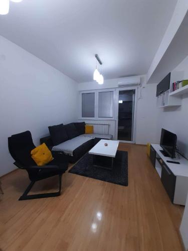 een woonkamer met een bank en een tafel bij Astrid Apartment in Skopje