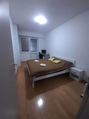 een slaapkamer met een bed in een witte kamer bij Astrid Apartment in Skopje