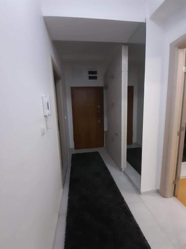 an empty hallway with a black rug in a room at Astrid Apartment in Skopje
