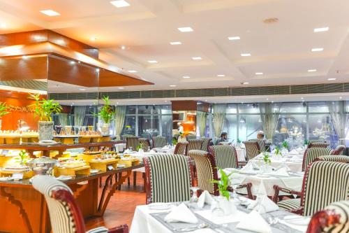 a dining room with tables and chairs and a restaurant at Hotel Sarina in Dhaka