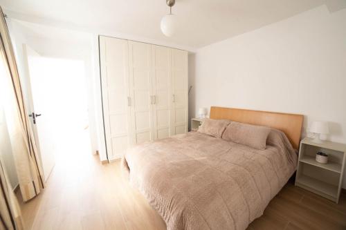 a bedroom with a large bed and a closet at ATICO CENTRO GANDIA in Gandía