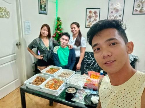 a young man standing in front of a table of food at Two-Bedroom at San Remo Oasis in Cebu City