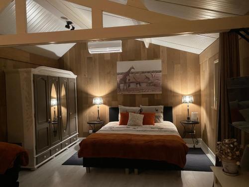 B & B d’ Uitwijkerpoort : غرفة نوم بسرير كبير وسقف مع انارة