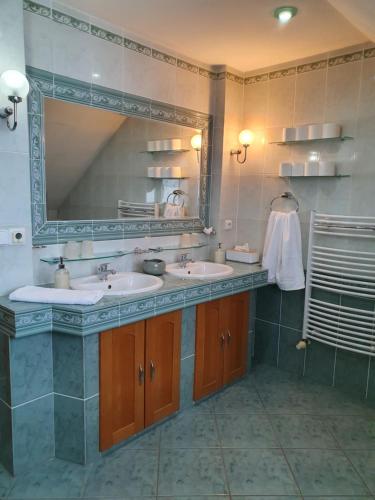 a bathroom with two sinks and a large mirror at WOW Liptov Holiday House in Liptovský Mikuláš