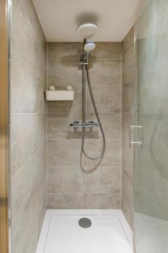une douche avec pommeau de douche dans une salle de bain dans l'établissement Paris Place Pantheon, à Paris