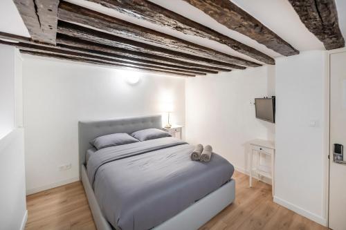 ein Schlafzimmer mit einem Bett in einem weißen Zimmer in der Unterkunft Paris Place Pantheon in Paris