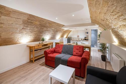 ein Wohnzimmer mit einem roten Sofa und einem Tisch in der Unterkunft Paris Place Pantheon in Paris