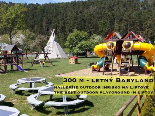 a park with a playground with a slide and a tent at Wellness Villa Liptov in Liptovská Sielnica