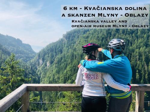 a man and a woman standing on a fence looking out over a valley at Wellness Villa Liptov in Liptovská Sielnica