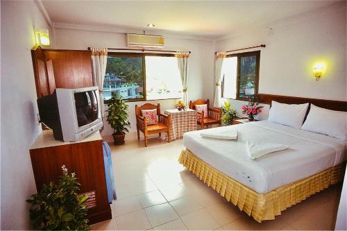 um quarto com uma cama e uma televisão em J Mansion em Praia de Aonang