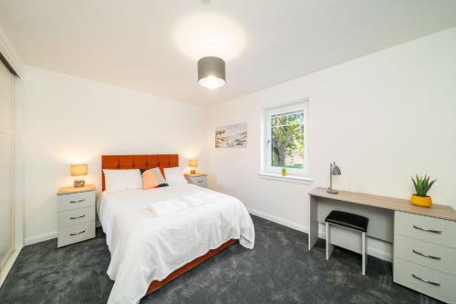 um quarto branco com uma cama e uma secretária em South Esk Apartment 5 em Montrose