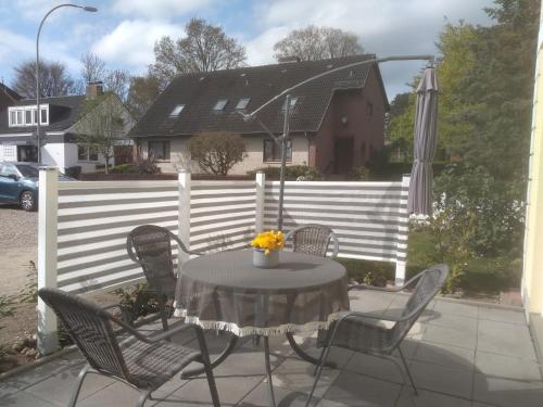 une table et des chaises assises sur une terrasse dans l'établissement Haus Malve Dahme, à Dahme