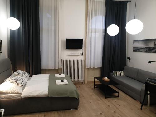 uma sala de estar com uma cama e um sofá em Apartmán Pribina em Nitra
