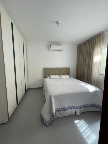 1 dormitorio con 1 cama en una habitación blanca en B e l a V i s t a, en Porto Seguro