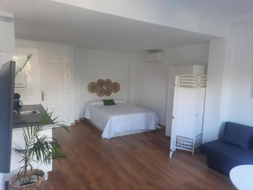 um quarto branco com uma cama e um lavatório. em Estudio Pedregalejo Garden Málaga em Málaga