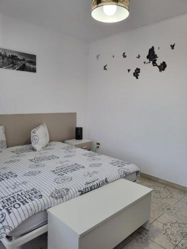 a white bedroom with a bed and a lamp at Pensiunea B&B Casa Italia in Timişoara