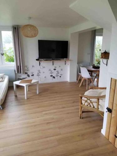 a living room with a flat screen tv on the wall at Gîte le Charmot, au pied des montagnes classé 3* in Roderen