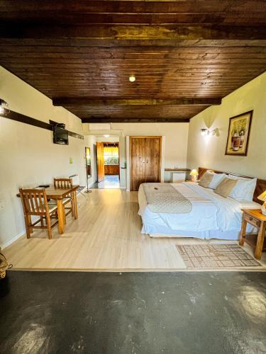 a bedroom with a large bed and a table at Hotel Fazenda Rota dos Cânions in Bom Jardim da Serra