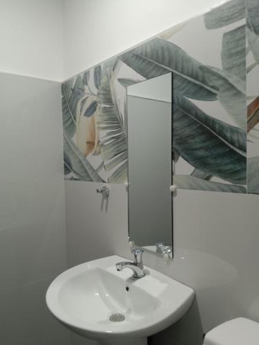 un bagno con lavandino e specchio di KIMURA PENSION a El Nido
