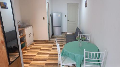 a kitchen with a table and chairs and a refrigerator at Departamentos villamar guanaquero in Coquimbo