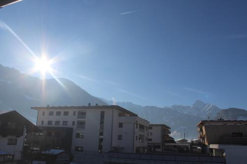 a sun shining over a city with mountains in the background at Apart 105 in Ramsau im Zillertal