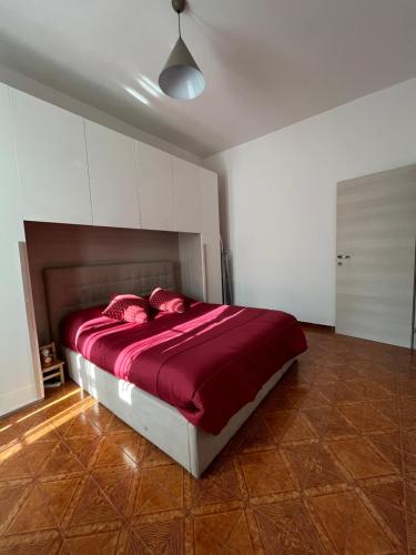 um quarto com uma cama grande e lençóis vermelhos em House vittone venaria reale 2 em Venaria Reale