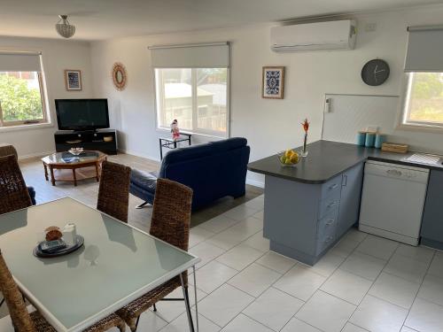 cocina y sala de estar con mesa y sillas en Beach Haven - Beach and Cafes on your doorstep - 3 bedrooms , Sleeps 6, en St Leonards