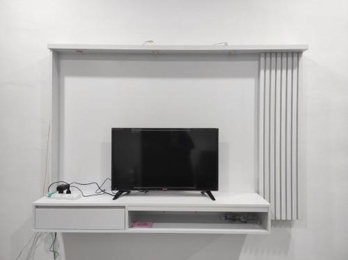 TV de pantalla plana en la parte superior de un estante blanco en BB D'VELODROM Homestay Dungun, en Dungun